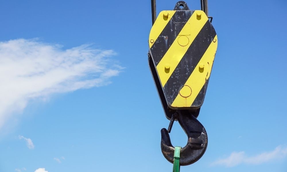 A pulley hanging freely from a construction machine.